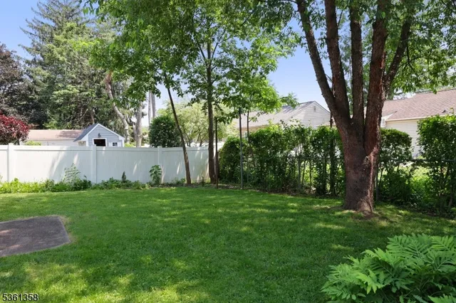 a view of a backyard with table and chairs and wooden fence
