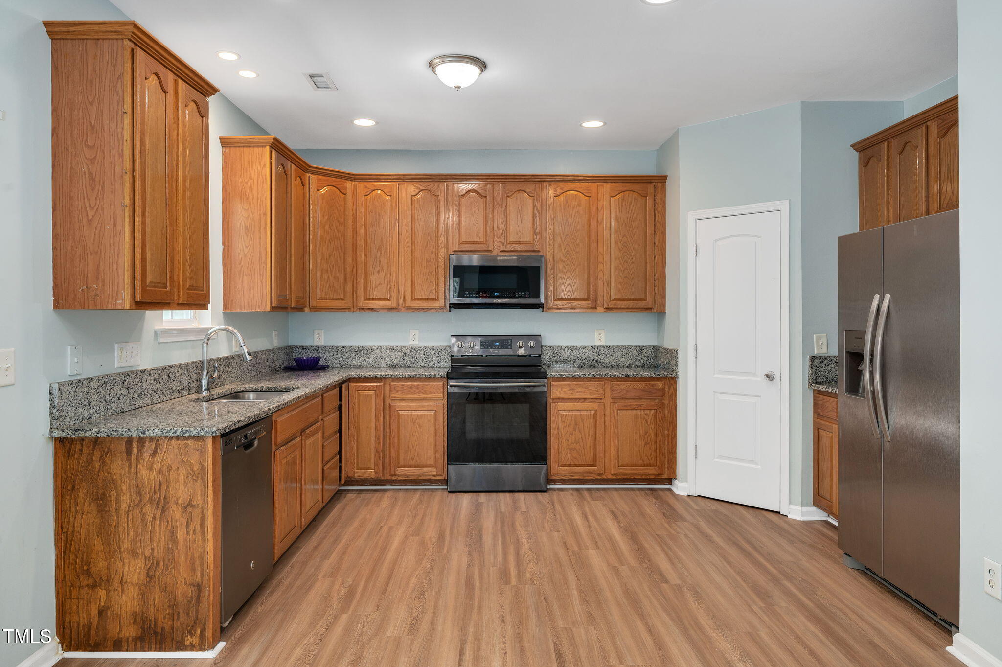 3805 Mike Levi Court Raleigh, NC 27610 - Photo 14 of 34 a kitchen with granite countertop wooden floors stainless steel appliances and sink