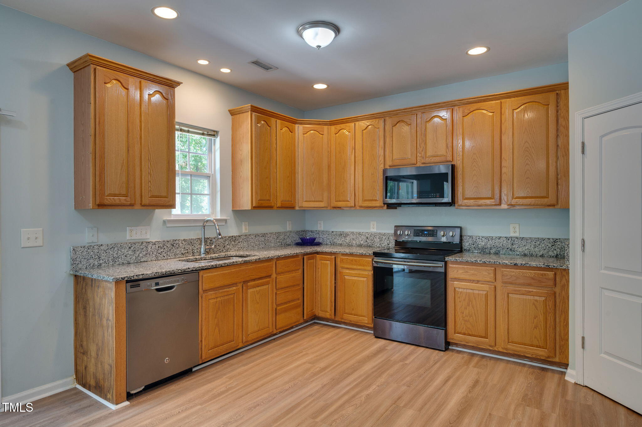 3805 Mike Levi Court Raleigh, NC 27610 - Photo 15 of 34 a kitchen with stainless steel appliances granite countertop wooden cabinets a sink dishwasher a stove and a refrigerator with wooden floor
