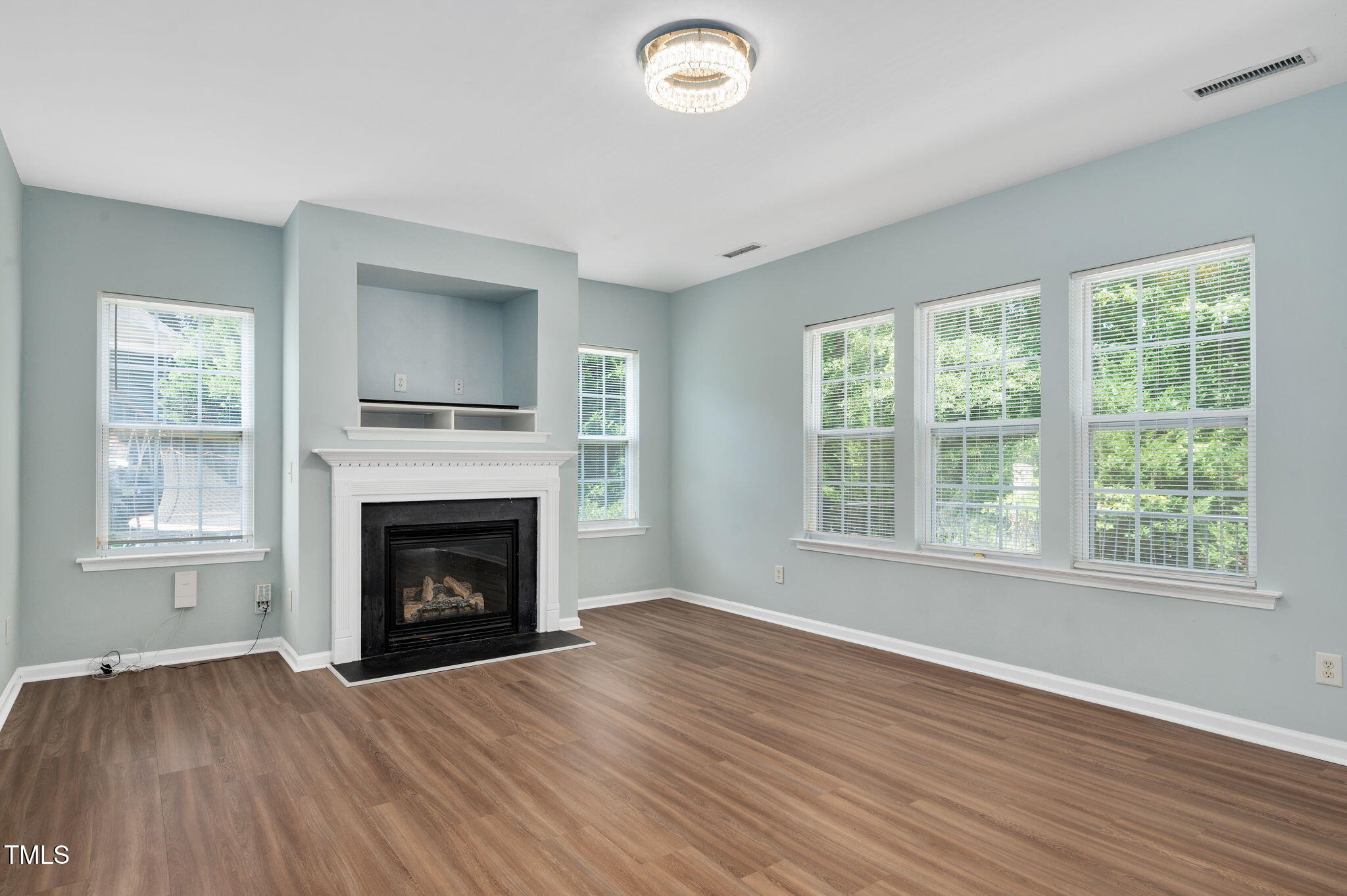 3805 Mike Levi Court Raleigh, NC 27610 - Photo 19 of 34 an empty room with wooden floor fireplace and windows