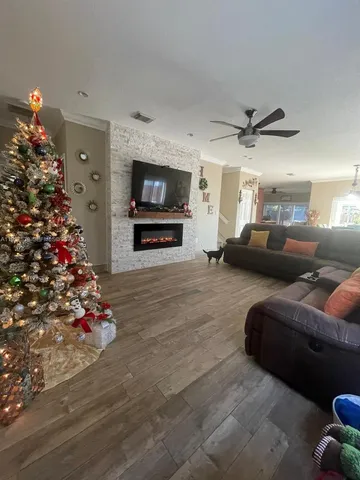 a living room with furniture flowers and a flat screen tv