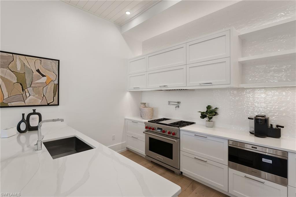 201 8th Street South, Unit 104 Naples, FL 34102 - Photo 12 of 40 a kitchen with white cabinets and white appliances