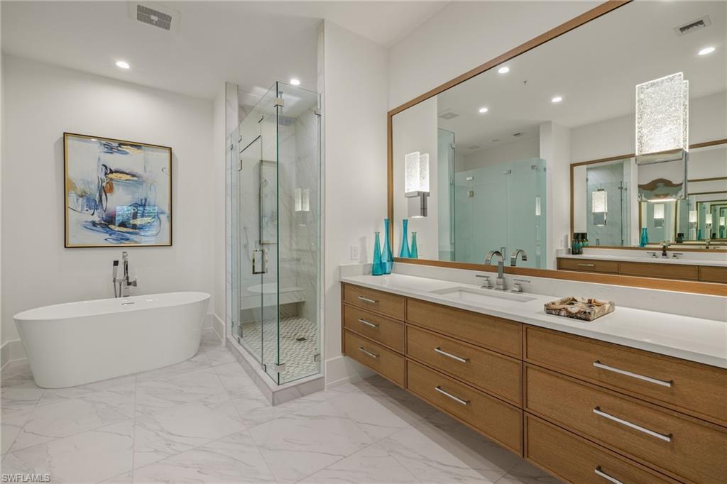 201 8th Street South, Unit 104 Naples, FL 34102 - Photo 17 of 40 a spacious bathroom with a tub sink mirror and vanity