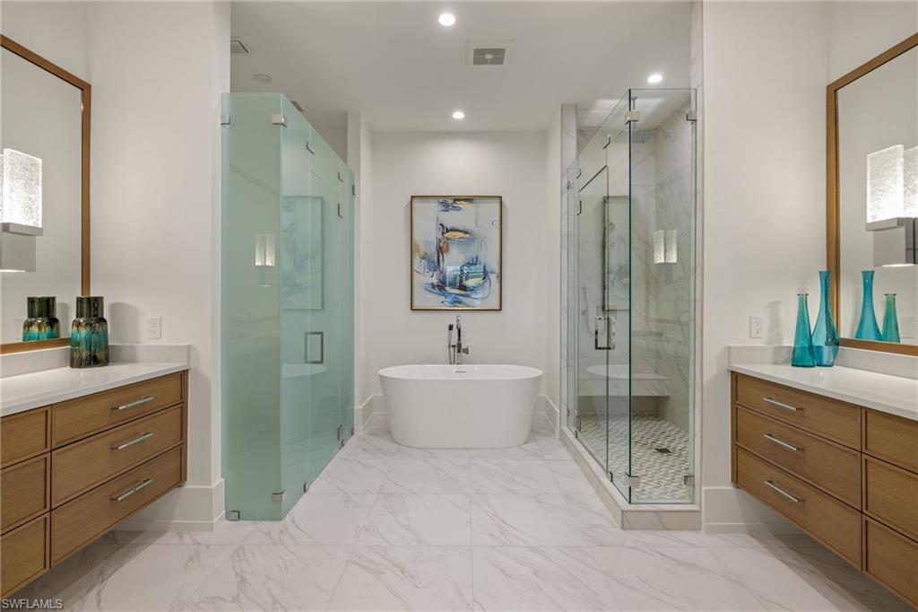 201 8th Street South, Unit 104 Naples, FL 34102 - Photo 18 of 40 a bathroom with a double vanity sink toilet and shower
