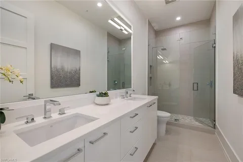 a bathroom with a double vanity sink mirror and toilet