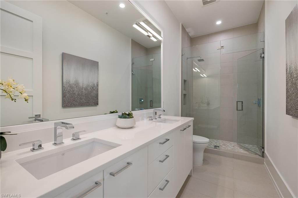 201 8th Street South, Unit 104 Naples, FL 34102 - Photo 20 of 40 a bathroom with a double vanity sink mirror and toilet