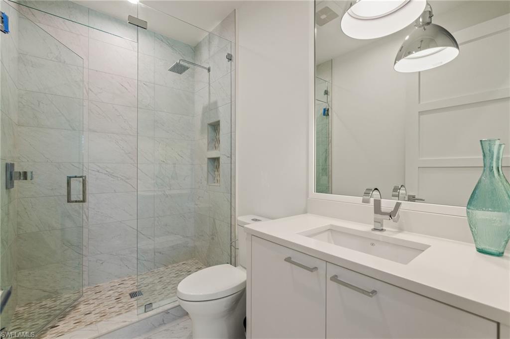 201 8th Street South, Unit 104 Naples, FL 34102 - Photo 22 of 40 a bathroom with a sink a toilet and shower
