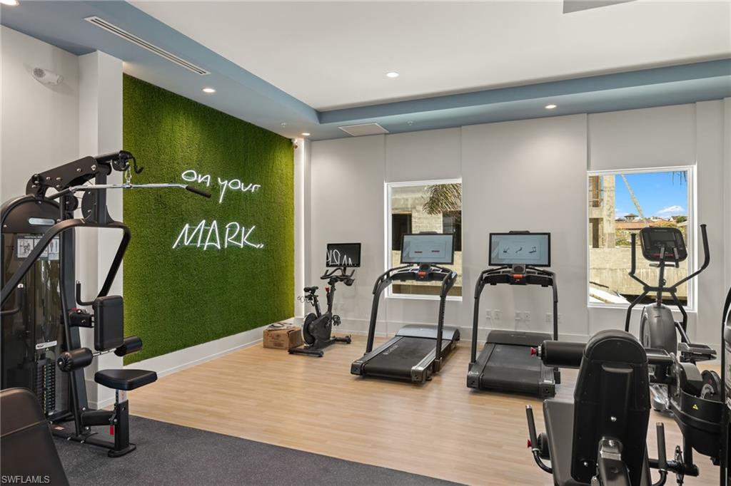 201 8th Street South, Unit 104 Naples, FL 34102 - Photo 31 of 40 a room with gym equipment and wooden floor