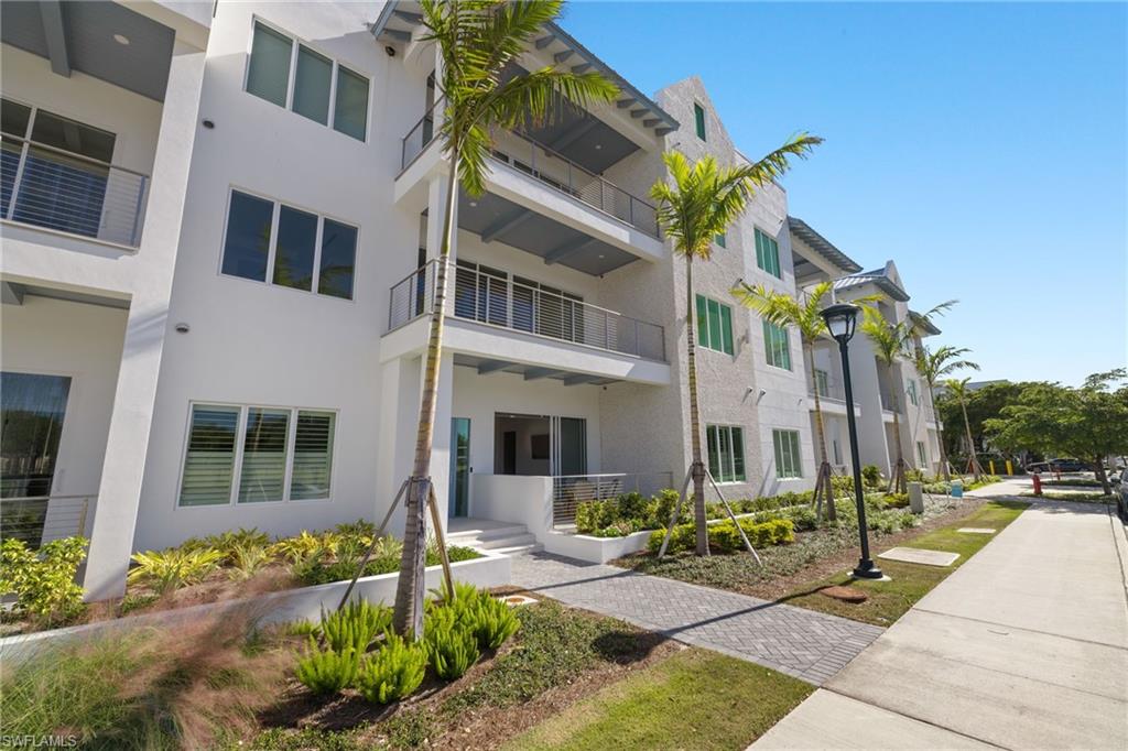 201 8th Street South, Unit 104 Naples, FL 34102 - Photo 37 of 40 a front view of a house with a garden
