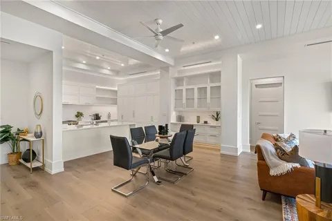 a view of a dining room with furniture a rug and wooden floor
