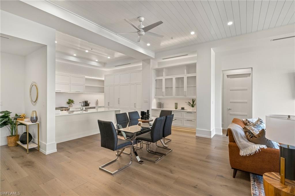 201 8th Street South, Unit 104 Naples, FL 34102 - Photo 8 of 40 a view of a dining room with furniture a rug and wooden floor