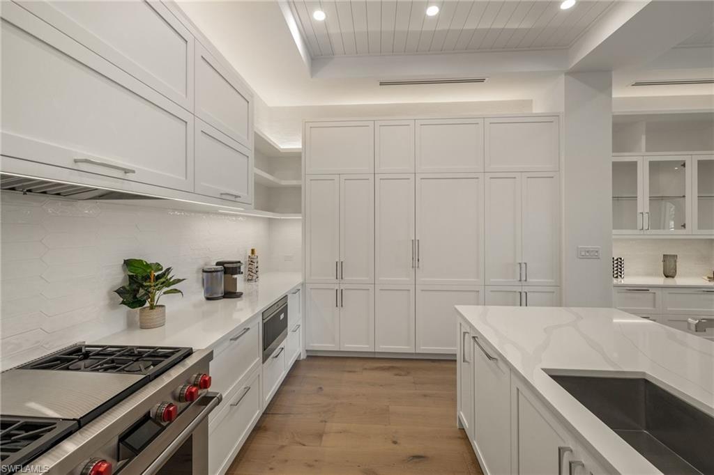 201 8th Street South, Unit 104 Naples, FL 34102 - Photo 10 of 40 a kitchen with granite countertop a sink stove and cabinets
