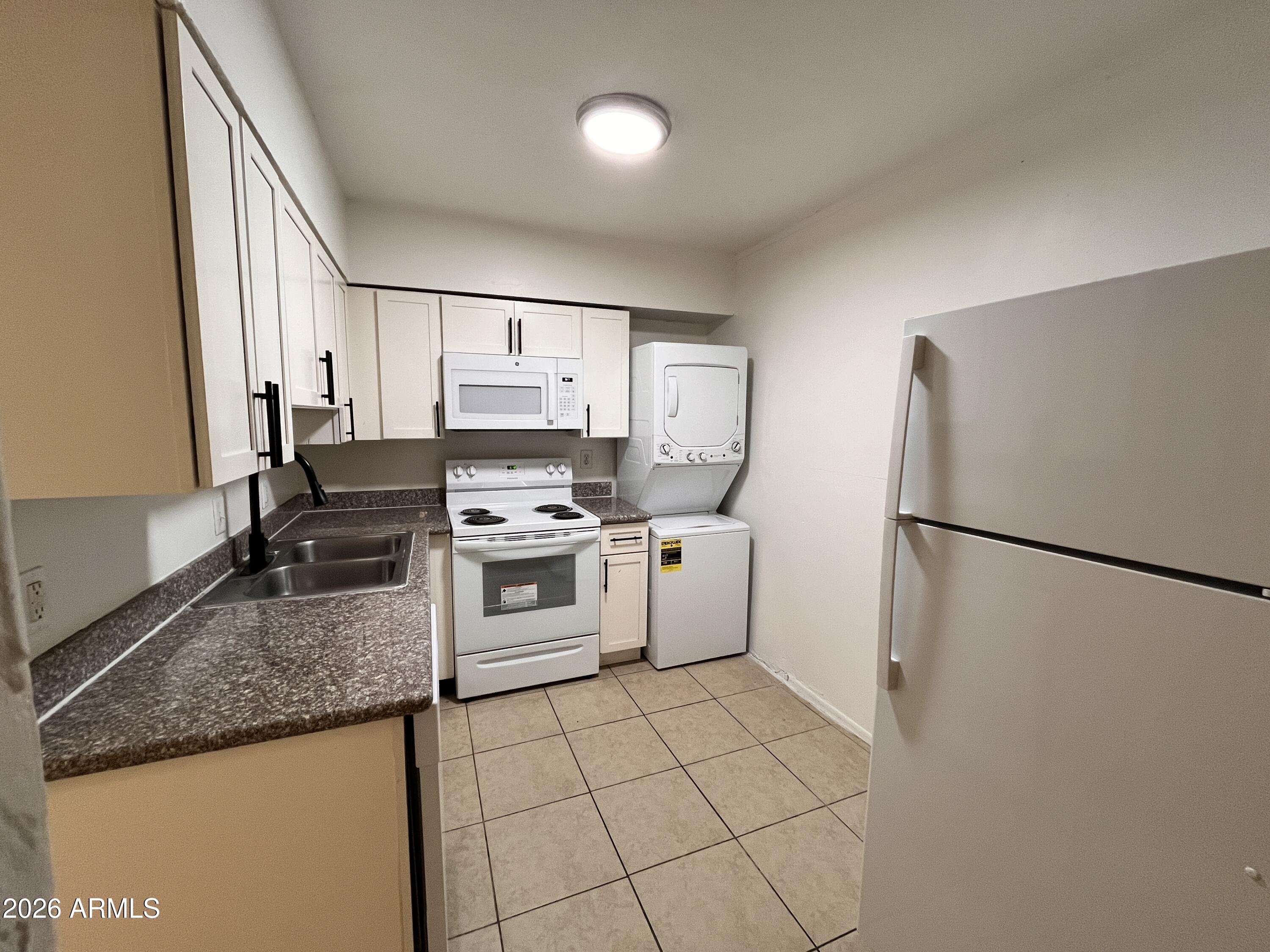 1224 South Smith Road Tempe, AZ 85281 - Photo 5 of 19 a kitchen with a refrigerator sink stove and cabinets