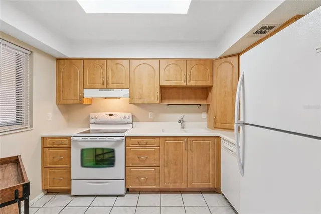a kitchen with a sink a refrigerator and cabinets
