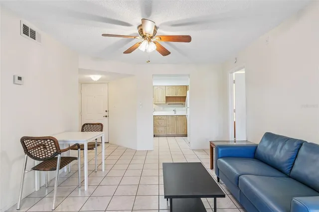 a living room with furniture a flat screen tv and kitchen view