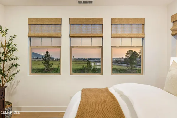 a bedroom with a bed and a large window with outer view