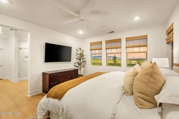 a bedroom with a bed tv and window