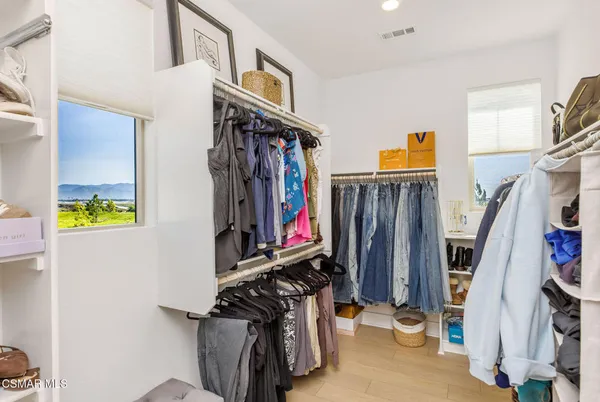 a view of walk in closet with clothes and shoes