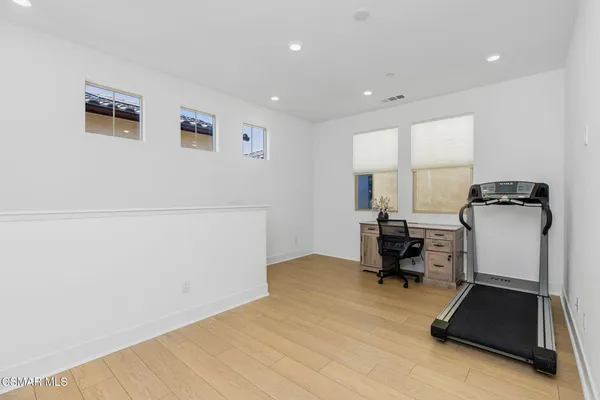 a view of a workspace with furniture and a window