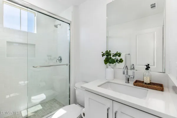 a bathroom with a granite countertop sink a toilet and shower