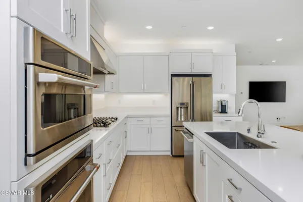 a kitchen with a sink stainless steel appliances and cabinets