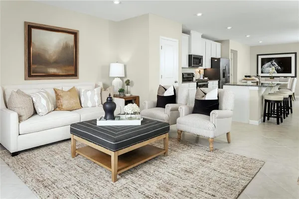 a living room with furniture and view of kitchen