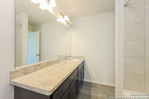 a bathroom with a granite countertop sink and a mirror