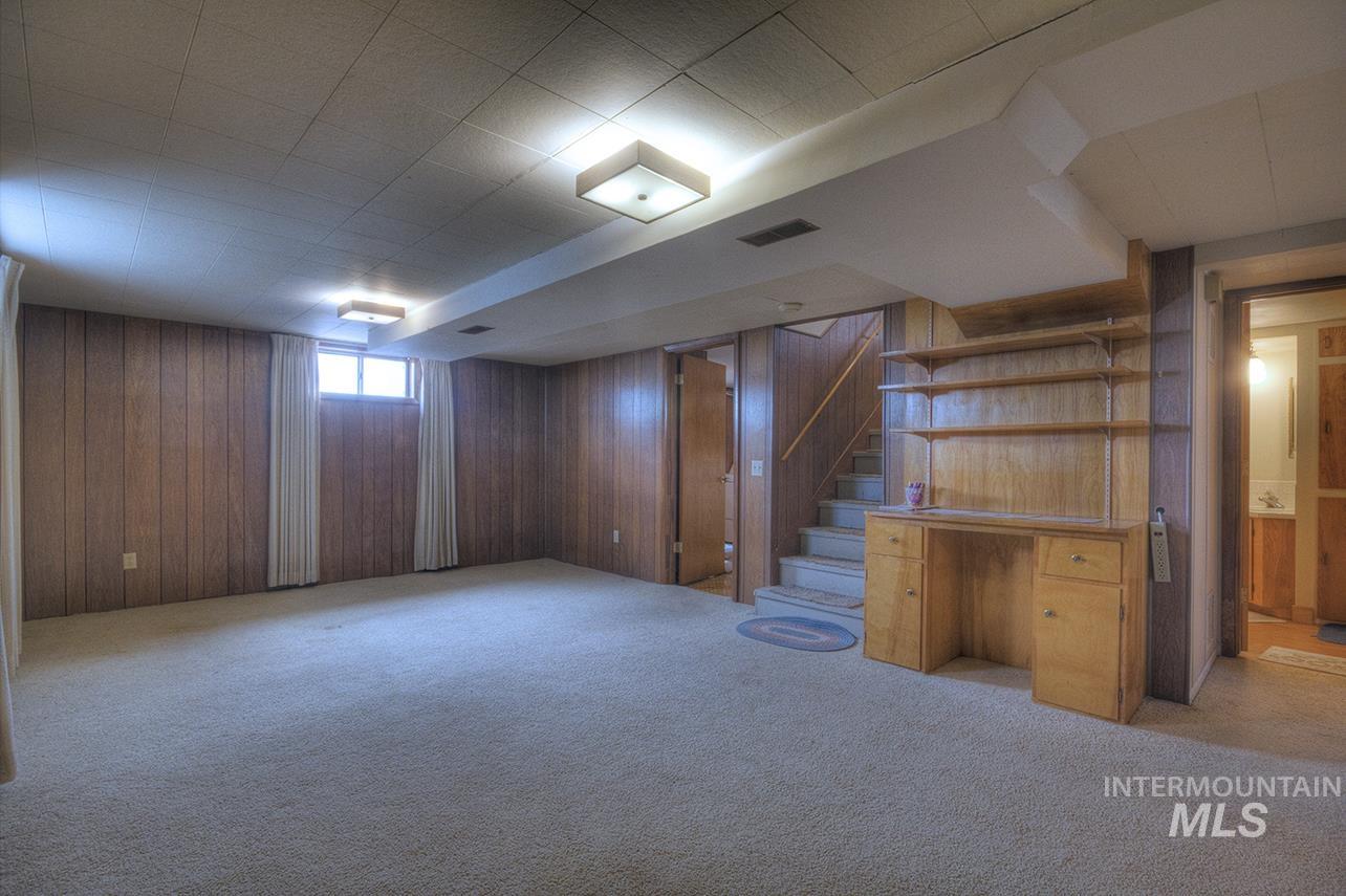 351 West Main Street South Vale, OR 97918 - Photo 8 of 33 Carpeted room featuring wood paneling, a built-in desk with shelving, and two windows