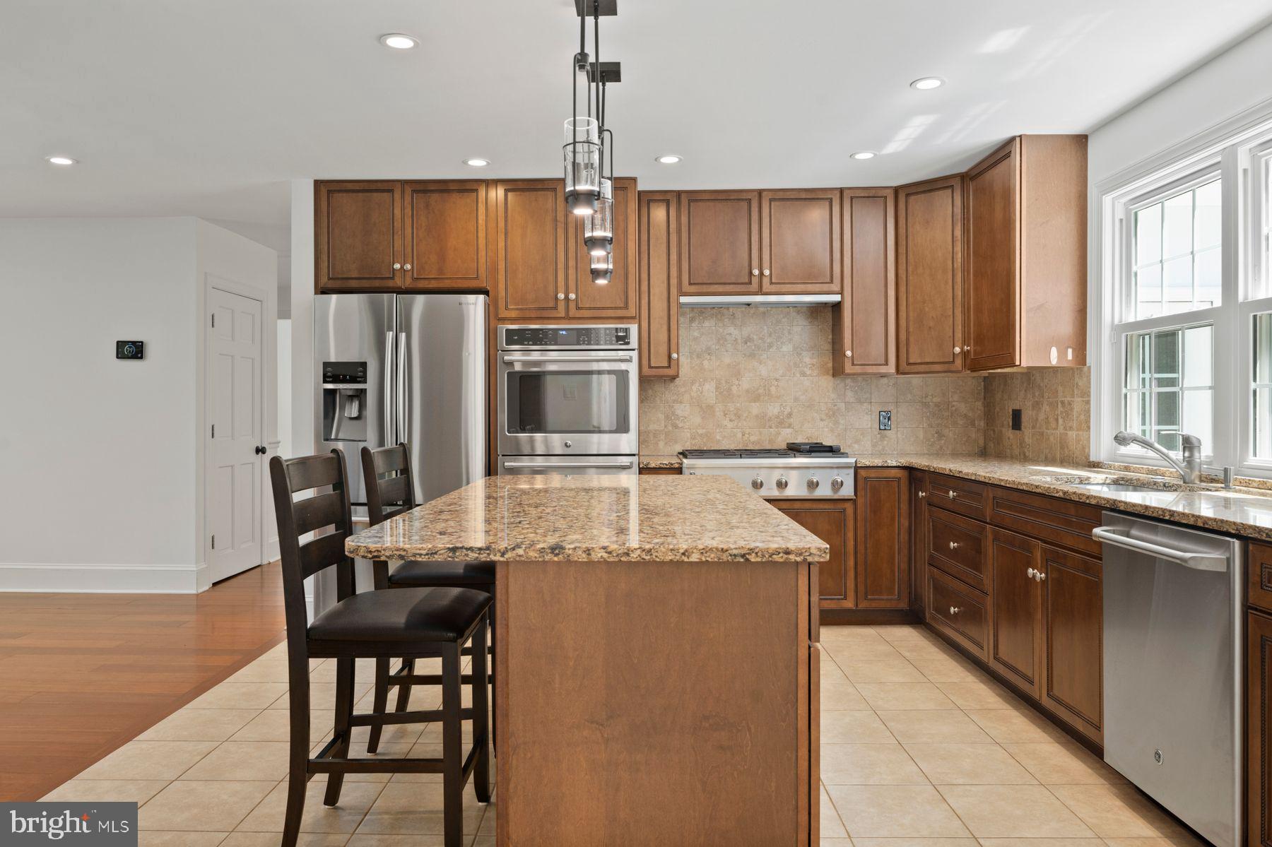 241 Line Road Malvern, PA 19355 - Photo 4 of 33 a kitchen with kitchen island granite countertop a table chairs microwave and refrigerator