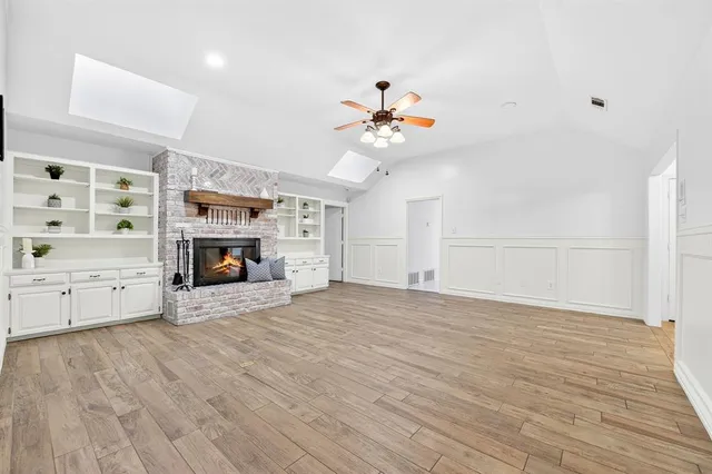 a view of empty room with a fireplace and wooden floor