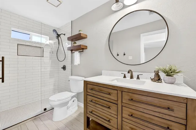 a bathroom with a sink a toilet and a mirror