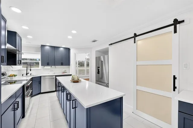 a kitchen with a sink a counter top space stainless steel appliances and cabinets