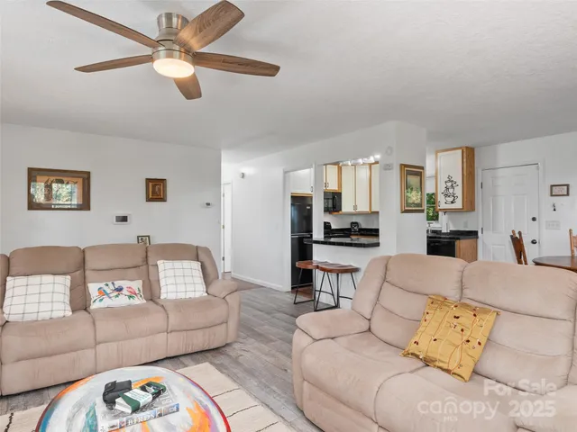 a living room with furniture and a view of kitchen