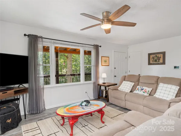 a living room with furniture a flat screen tv and a large window