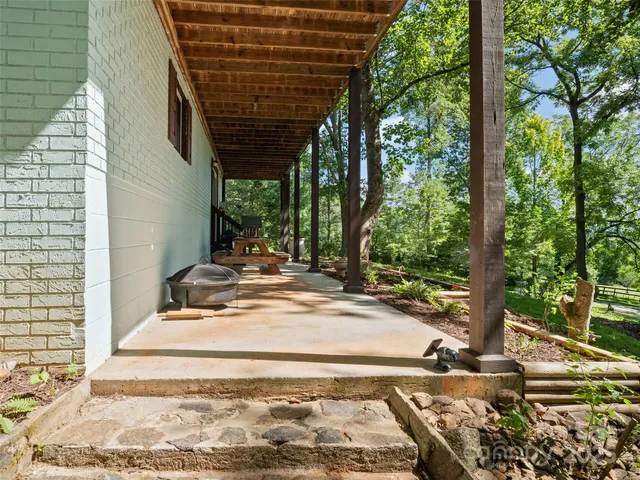 a view of a backyard with table and chairs and wooden fence