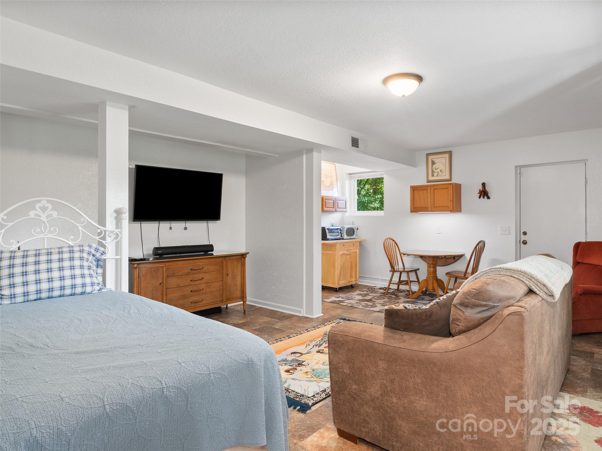 290 Turkey Pen Road Franklin, NC 28734 - Photo 25 of 37 a bedroom with a bed and a flat screen tv