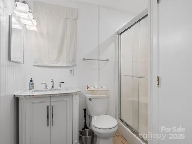 a bathroom with a toilet sink vanity and mirror