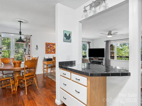 a kitchen with stainless steel appliances granite countertop a stove top oven a dining table and chairs with wooden floor