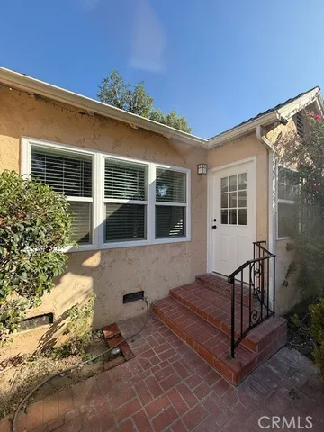 a view of house with backyard and sitting area