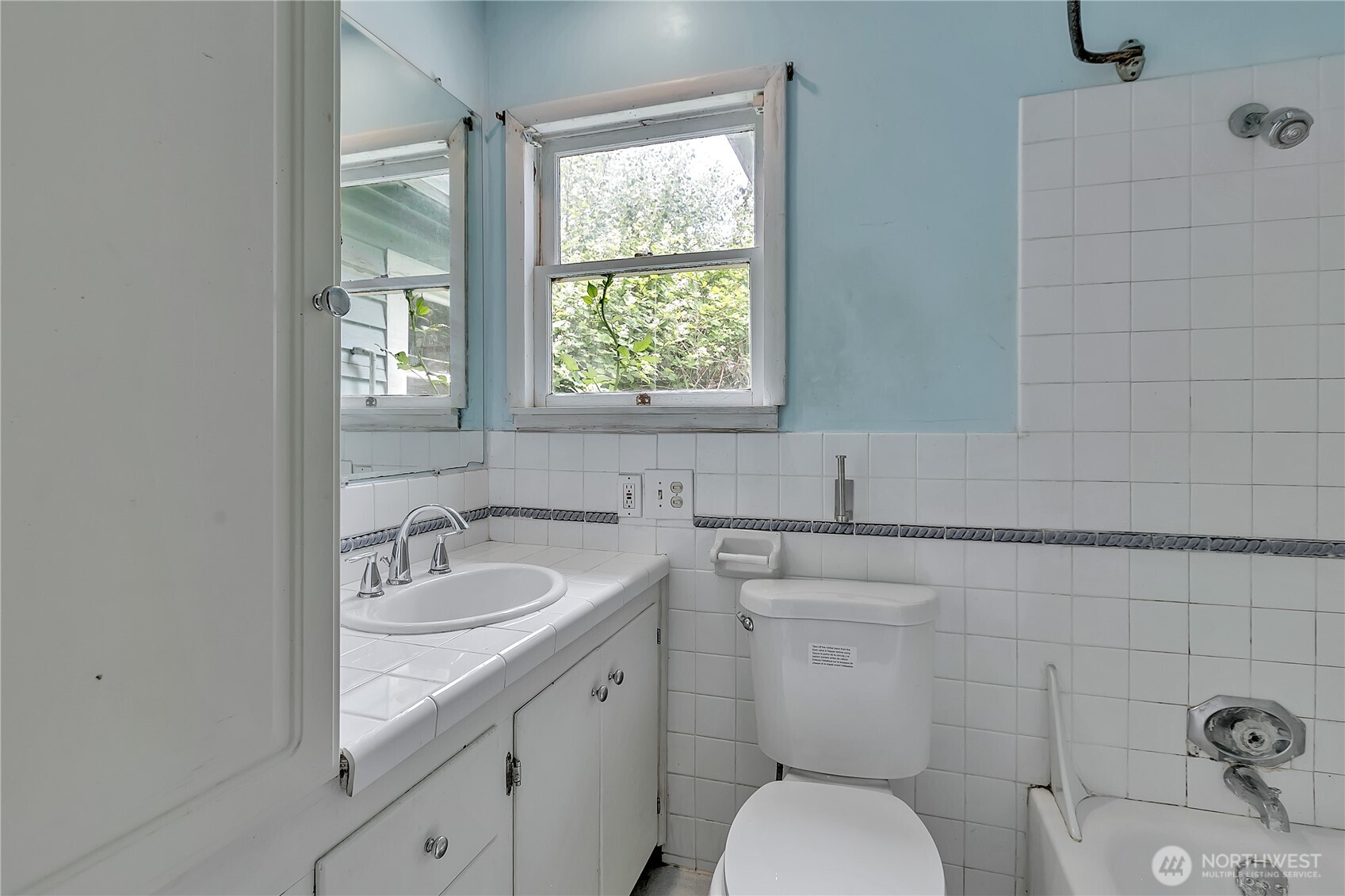 2209 Talbot Road South Renton, WA 98055 - Photo 4 of 8 a bathroom with a granite countertop toilet a sink and a window