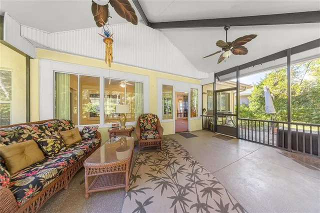 a living room with furniture tv and large windows