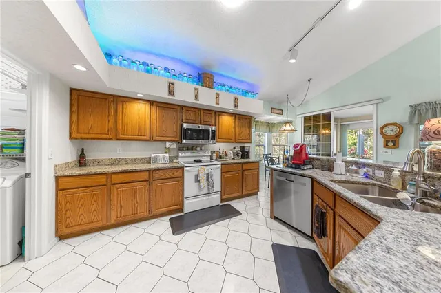 a kitchen with stainless steel appliances granite countertop a sink and cabinets