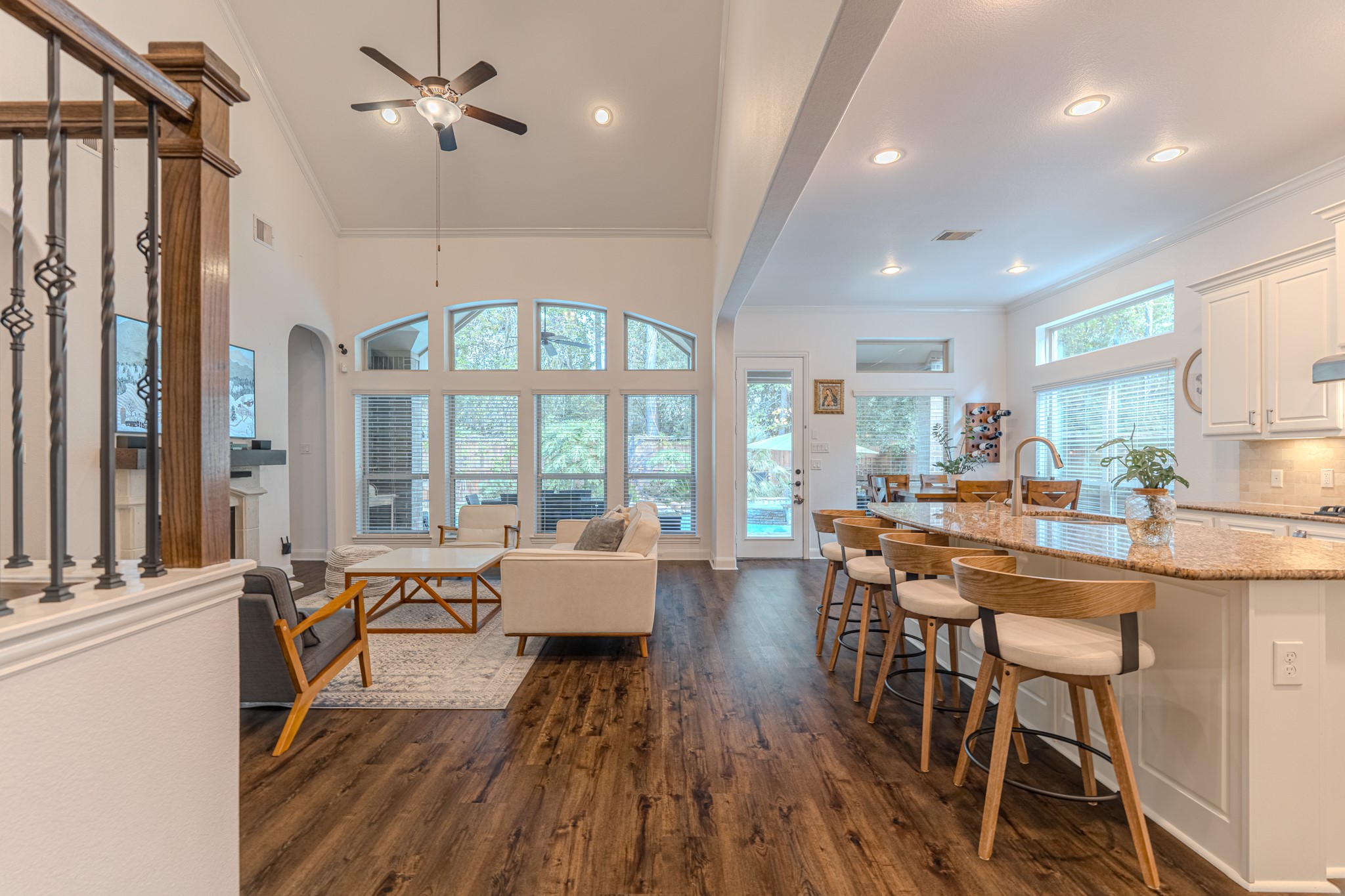 30 Fury Ranch Place The Woodlands, TX 77375 - Photo 14 of 47 This bright, open-concept living area features high ceilings, a modern kitchen with a large island and bar seating, and a cozy living room with large windows offering plenty of natural light. The space seamlessly connects to the dining area, creating an inviting atmosphere for entertaining.