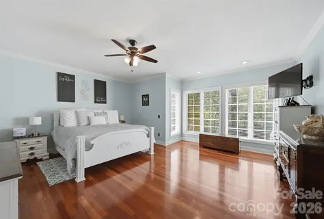 a spacious bedroom with a large bed and a flat tv screen