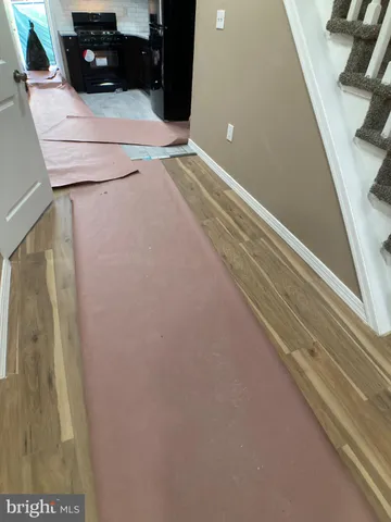 a view of a hallway with wooden floor and stairs