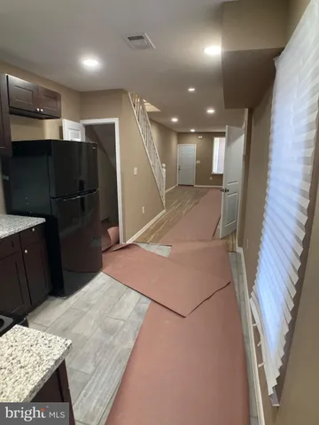 a view of a hallway with wooden floor and closet