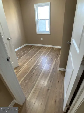 an empty room with wooden floor and window