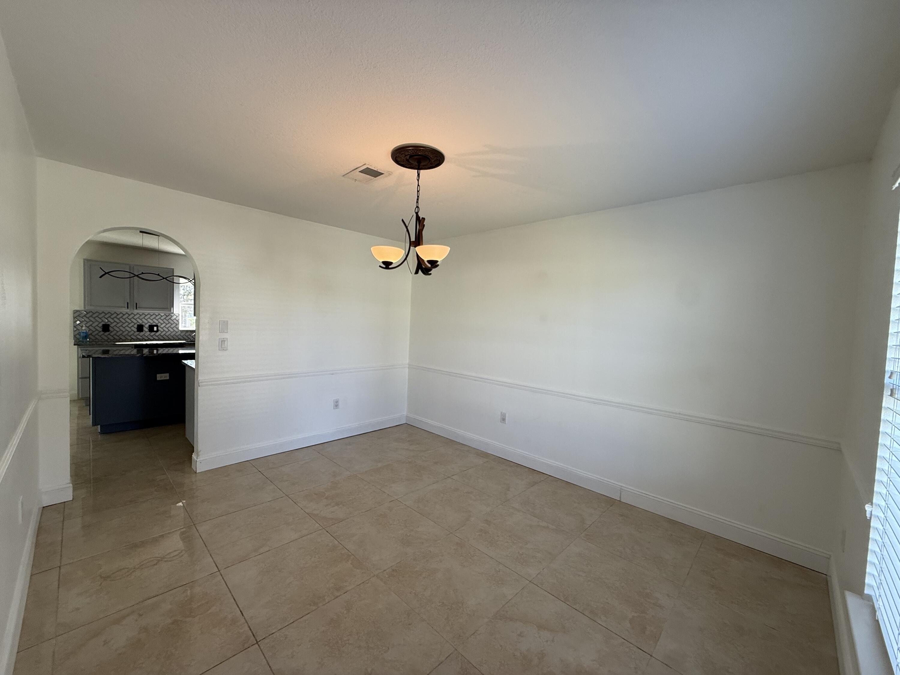 1925 Southwest Libra Lane Port St. Lucie, FL 34984 - Photo 11 of 49 a view of a kitchen with a sink and a refrigerator