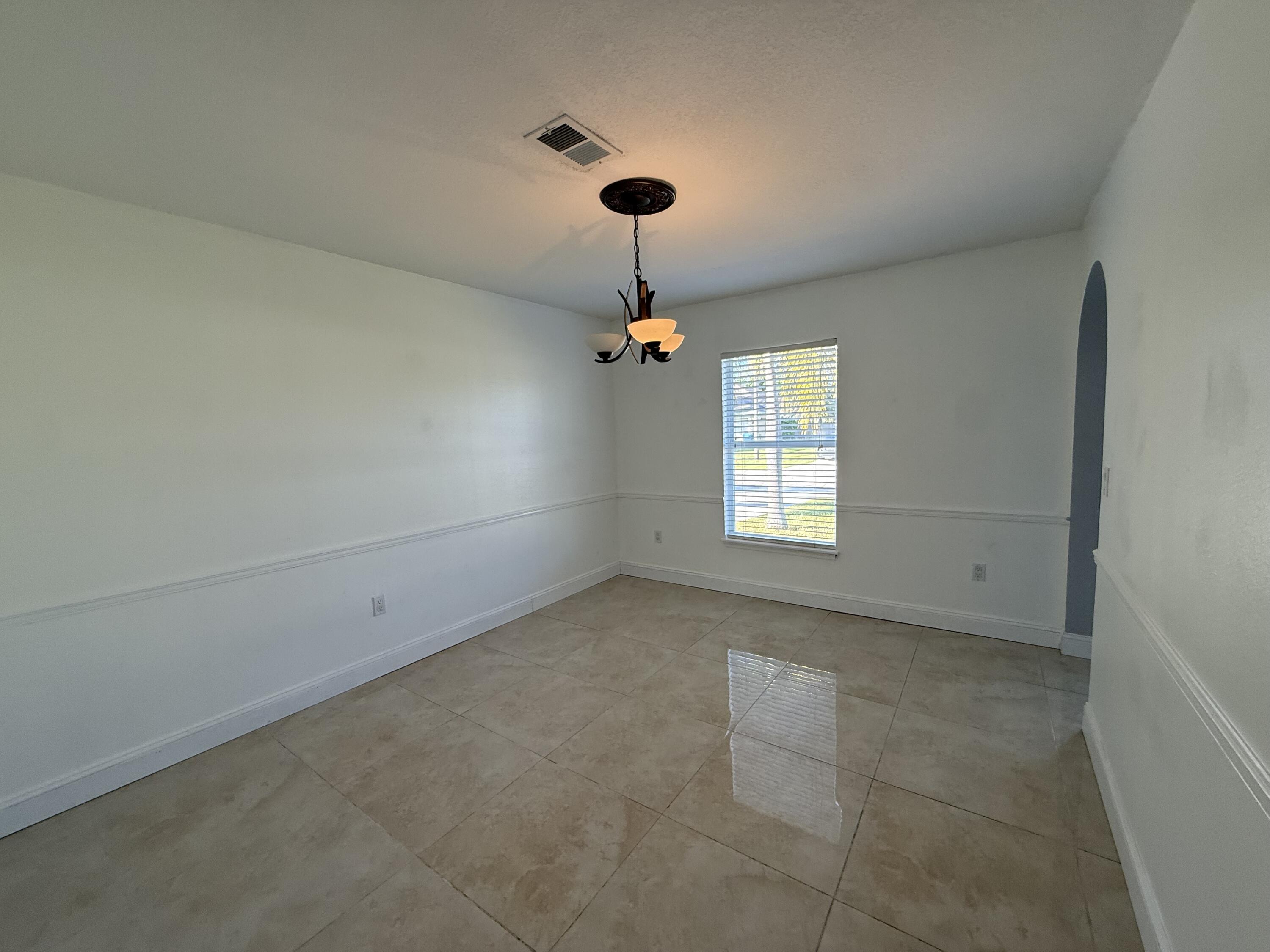 1925 Southwest Libra Lane Port St. Lucie, FL 34984 - Photo 12 of 49 an empty room with a window and a ceiling fan