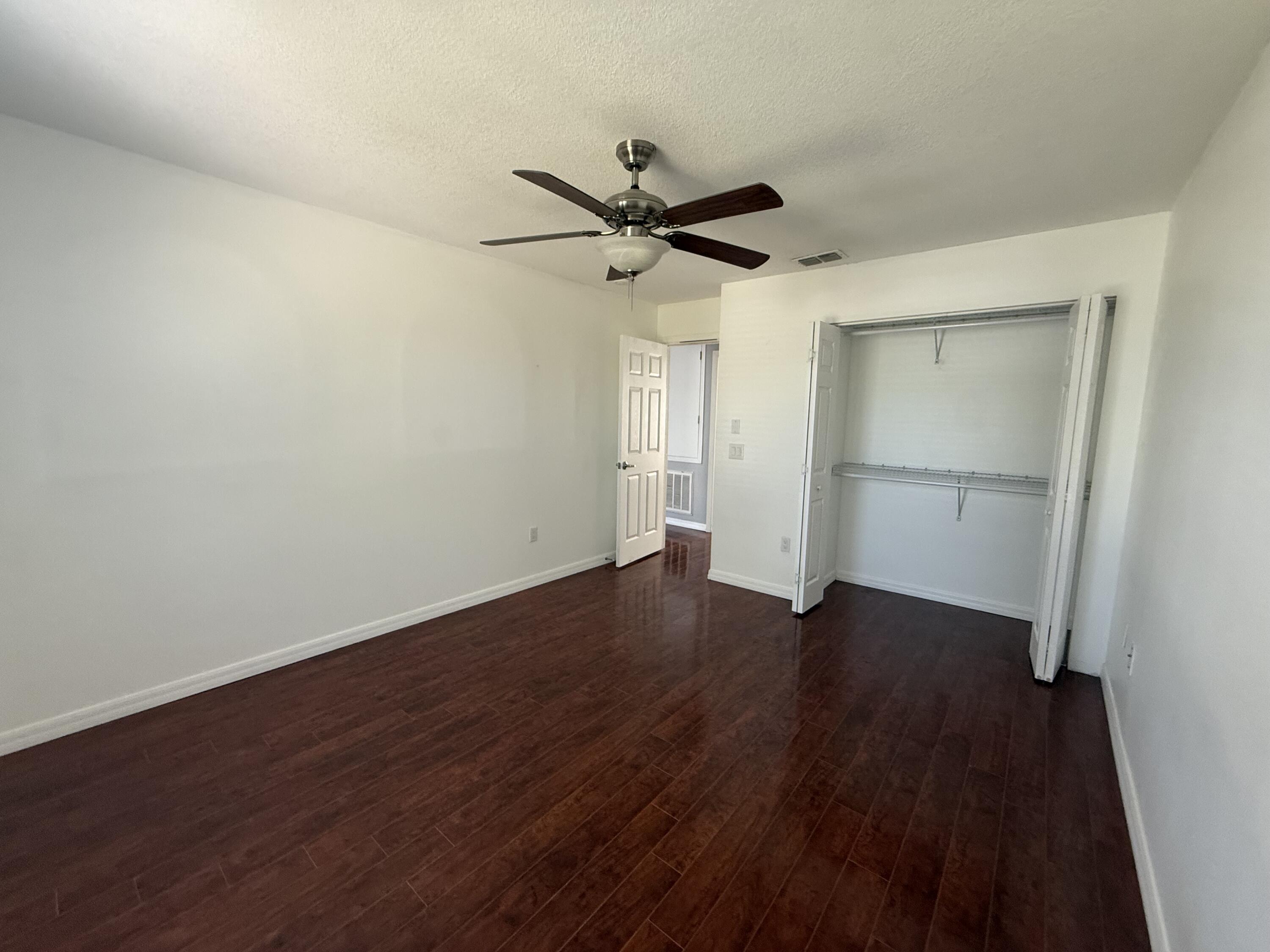 1925 Southwest Libra Lane Port St. Lucie, FL 34984 - Photo 30 of 49 an empty room with wooden floor ceiling fan and windows